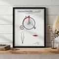 Framed patent poster of a vintage bicycle on a wooden shelf with decorative elements.