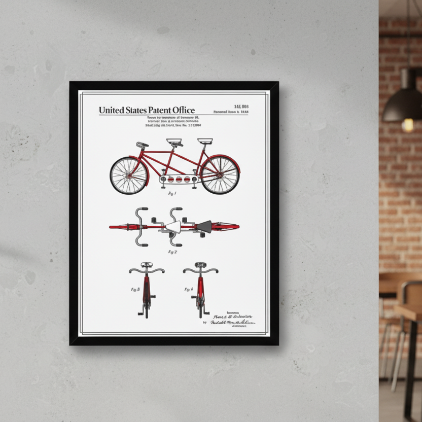 Framed bicycle patent print on a wall in a room with a brick wall and wooden furniture.